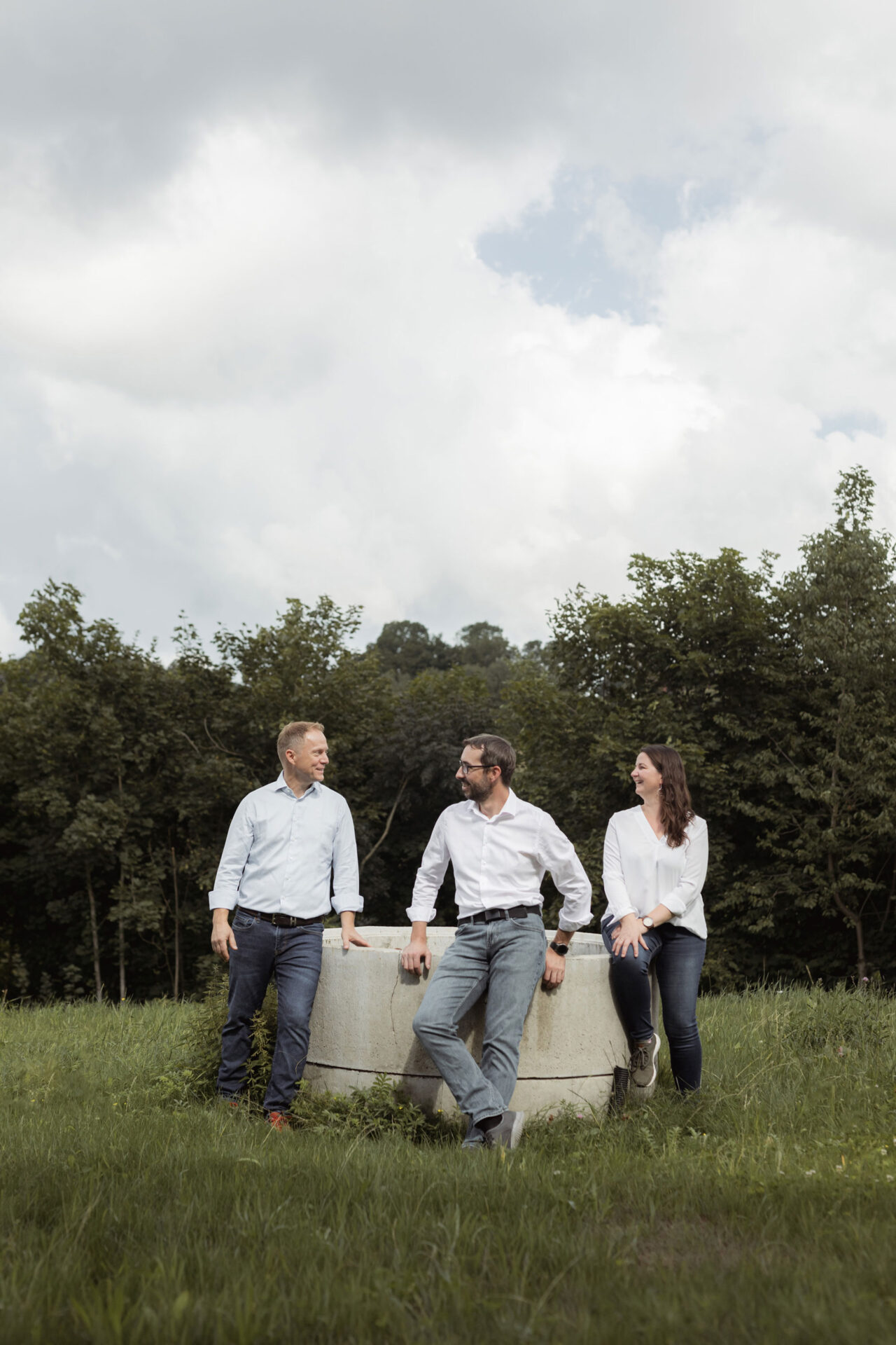 Das Team draußen auf Beton Zylinder, im Gespräch